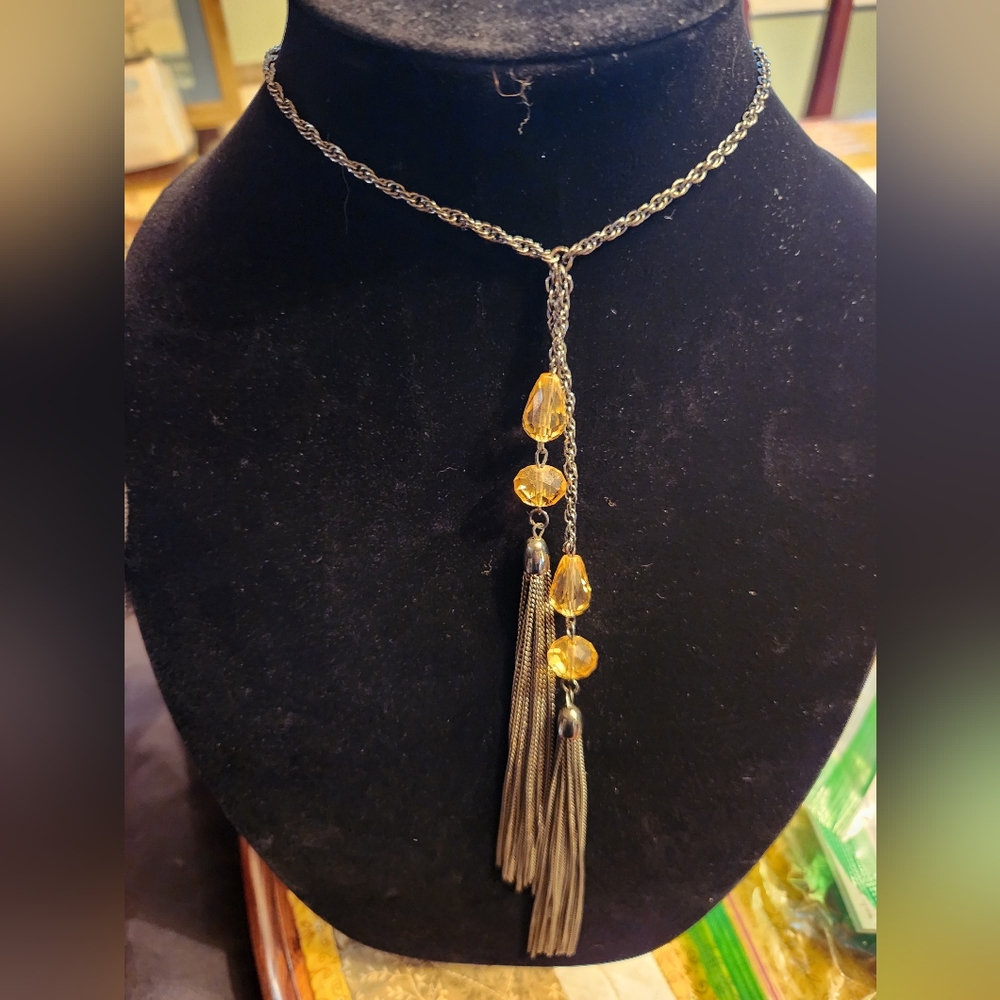 Long necklace with yellow colored beads with tassel.